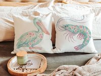 CapableByDesign floral pelican and floral shrimp throw pillows and matching towels