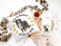 May include: White pillow and towel set with a Bernese Mountain Dog illustration and the text "life is better with a dog." Yellow tennis balls are also featured in the design. A wooden bucket and decorative garland are in the background.